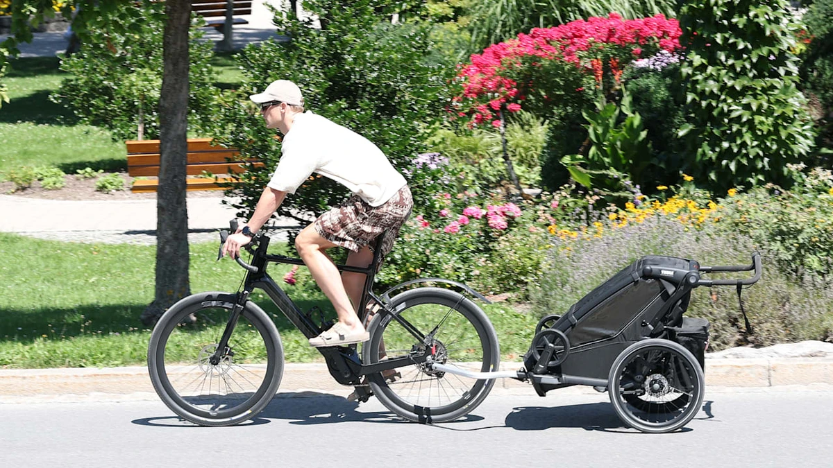 Manuel Neuer kommt mit Kinder-Anhänger im Trainingslager der Bayern an